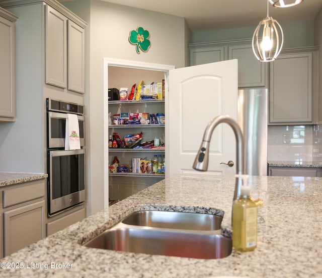 2854 Hamilton Springs Dr, Louisville, KY 40245 - kitchen with stainless steel double oven, a sink, backsplash, and light stone countertops