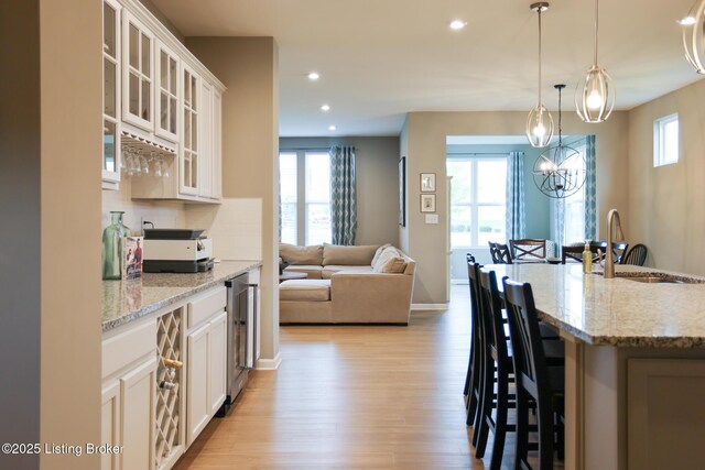 2854 Hamilton Springs Dr, Louisville, KY 40245 - kitchen featuring light wood-style floors, a breakfast bar area, a sink, recessed lighting, and hanging light fixtures