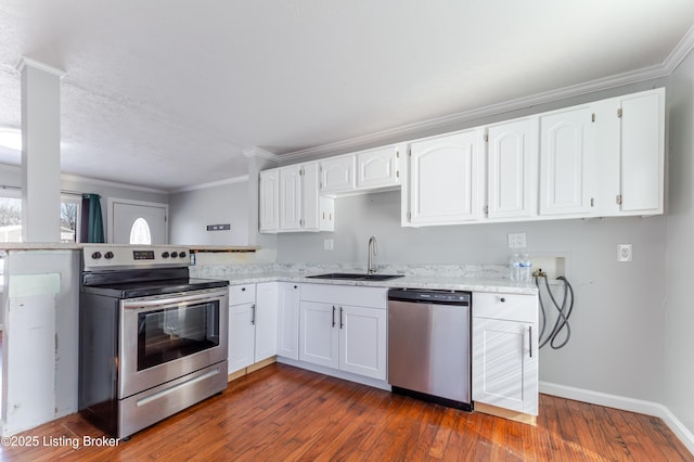 kitchen featuring a sink, appliances with stainless steel finishes, dark wood-style floors, and ornamental molding