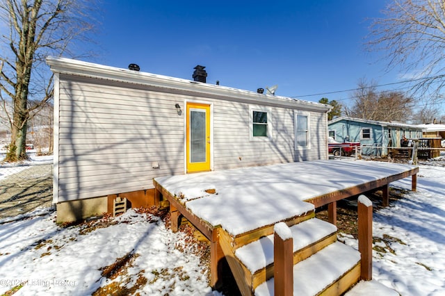 snow covered property featuring a wooden deck