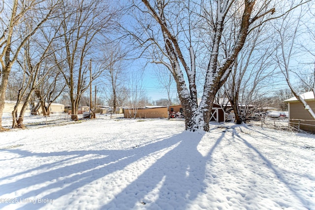 yard layered in snow featuring fence