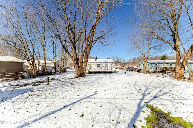 yard layered in snow with fence and a wooden deck