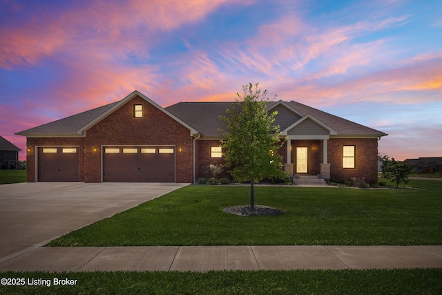 view of front of home featuring an attached garage, concrete driveway, a front lawn, and brick siding
