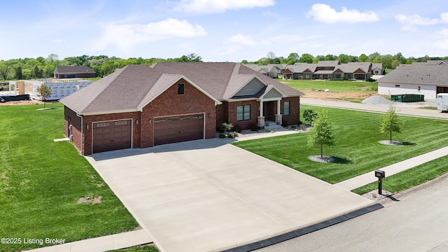 view of front facade with a shingled roof, an attached garage, a front lawn, brick siding, and concrete driveway