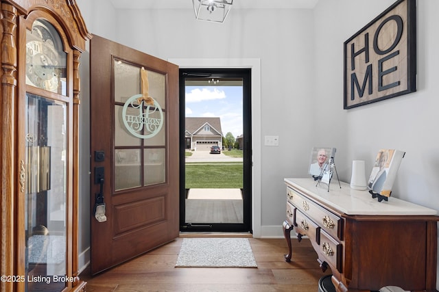 foyer entrance with baseboards and wood finished floors