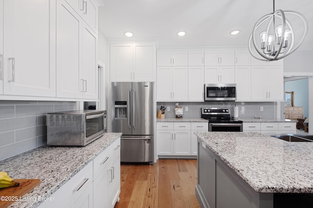 kitchen featuring white cabinetry, appliances with stainless steel finishes, and decorative backsplash