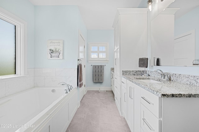 full bathroom featuring a garden tub and vanity