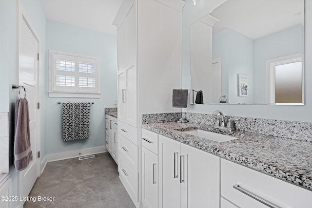 bathroom with baseboards, visible vents, and vanity