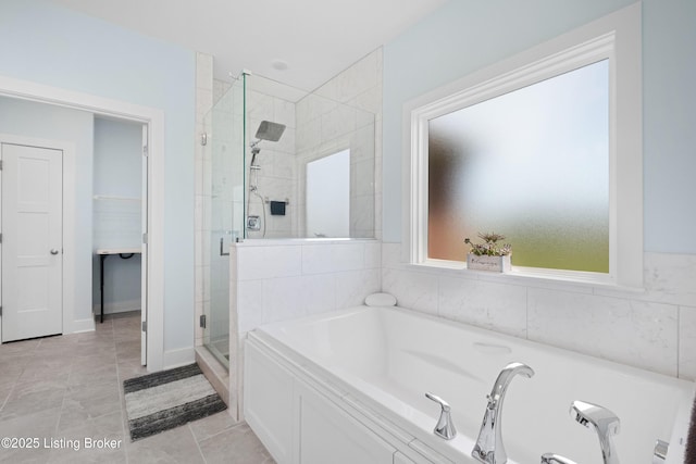 bathroom featuring tile patterned flooring, a shower stall, and a garden tub