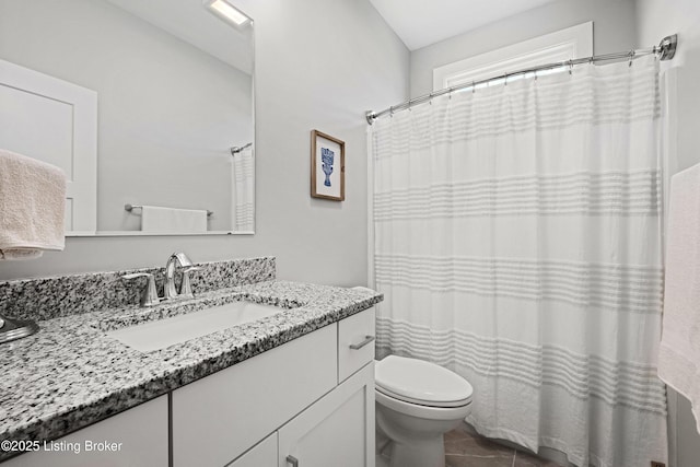 bathroom featuring vanity, tile patterned floors, and toilet