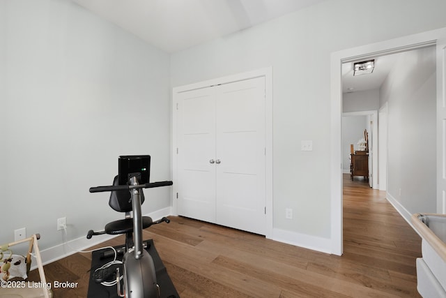 workout room with baseboards and wood finished floors