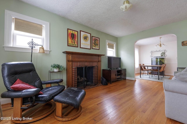 602 Merwin Ave, Louisville, KY 40217 - living area featuring arched walkways, a textured ceiling, wood finished floors, and a fireplace