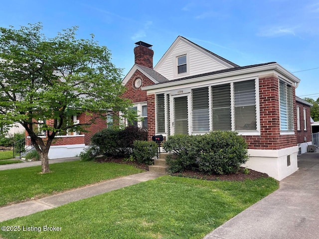 602 Merwin Ave, Louisville, KY 40217 - view of front facade featuring a chimney, a front yard, and brick siding