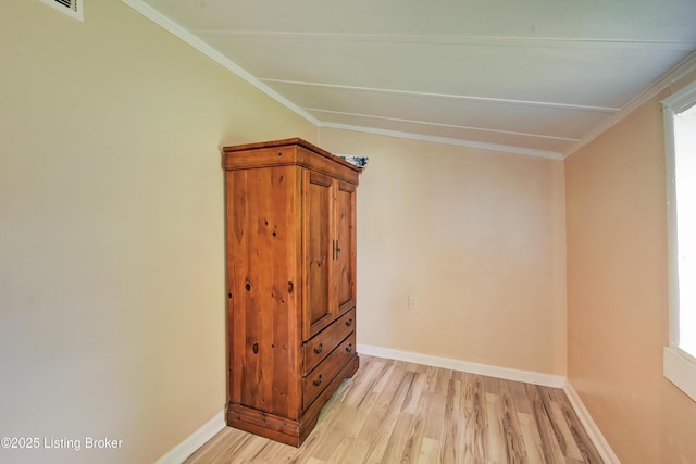 spare room with baseboards, visible vents, ornamental molding, and light wood-style floors