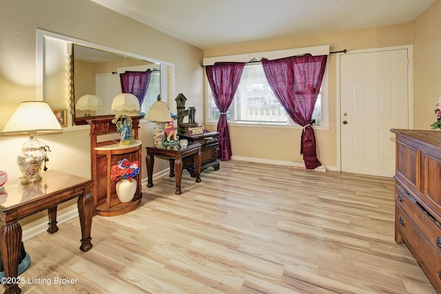 sitting room featuring baseboards and light wood-style flooring