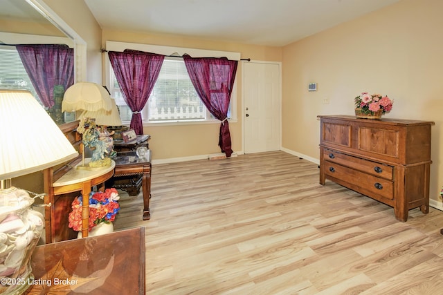 living area with baseboards and light wood finished floors