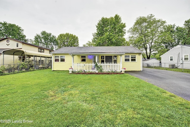 ranch-style home with a front lawn, aphalt driveway, fence, a porch, and central air condition unit