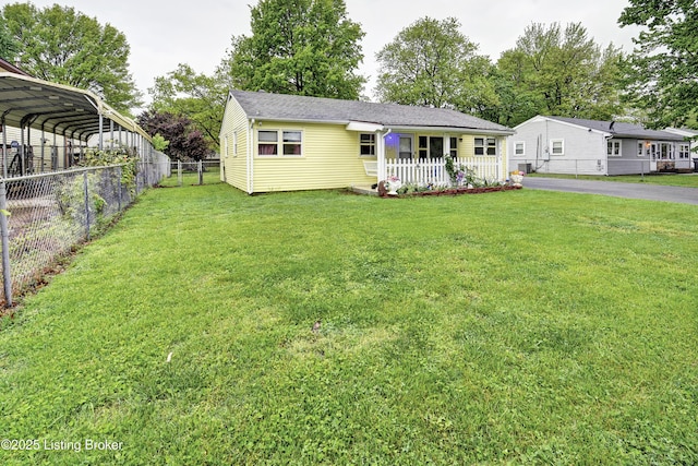 view of front of property featuring a detached carport, a front lawn, fence, a porch, and driveway