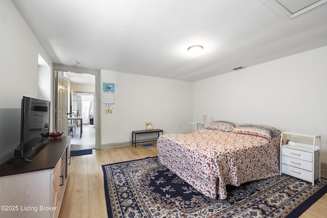 bedroom featuring baseboards, visible vents, and light wood-type flooring