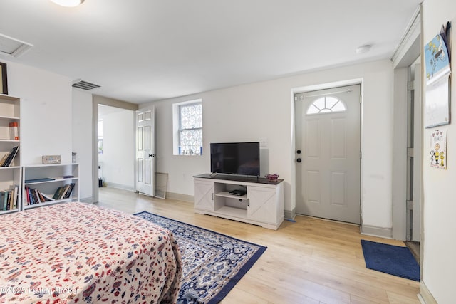 bedroom featuring baseboards, visible vents, attic access, and light wood-style floors