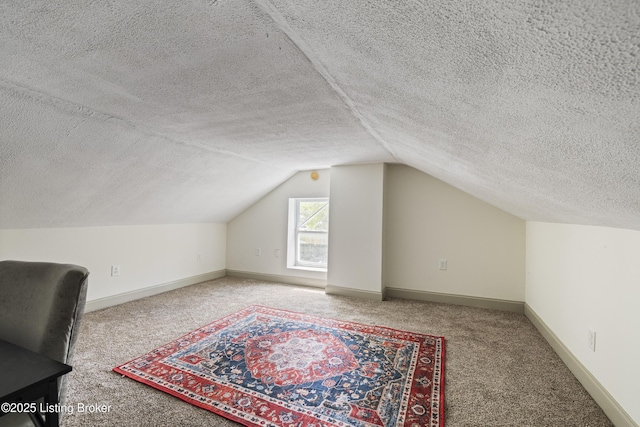 additional living space with carpet floors, a textured ceiling, and lofted ceiling