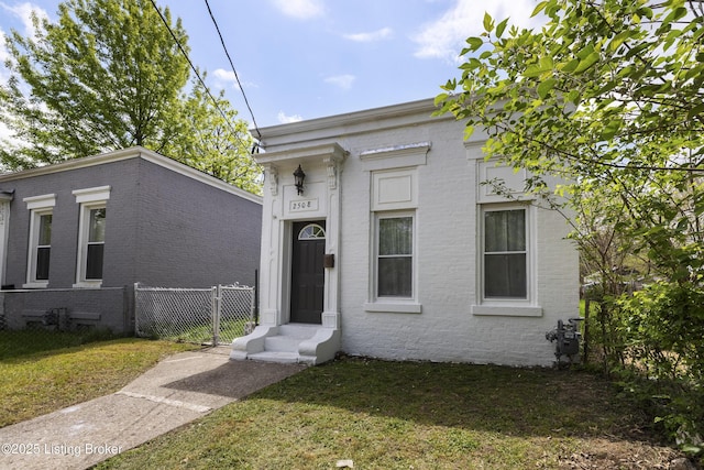 view of front of property with entry steps, fence, a front yard, and brick siding