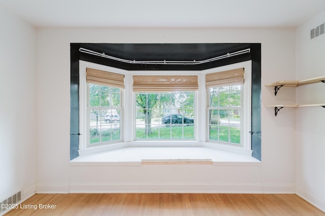 room details featuring visible vents, wood finished floors, and baseboards