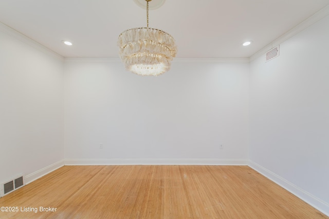 spare room with light wood finished floors, visible vents, baseboards, and a notable chandelier
