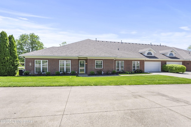 view of front of home with brick siding, a front lawn, an attached garage, and driveway