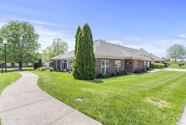 view of property exterior featuring brick siding and a lawn