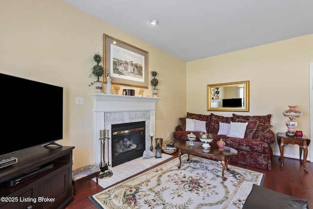 living room featuring recessed lighting, a high end fireplace, and dark wood-style flooring