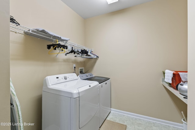 clothes washing area featuring laundry area, baseboards, and washer and dryer