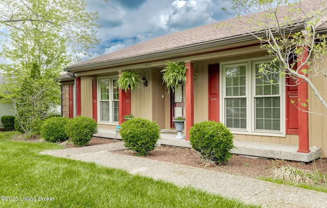 entrance to property featuring roof with shingles