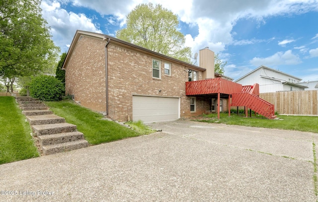 back of house featuring fence, an attached garage, brick siding, stairway, and concrete driveway