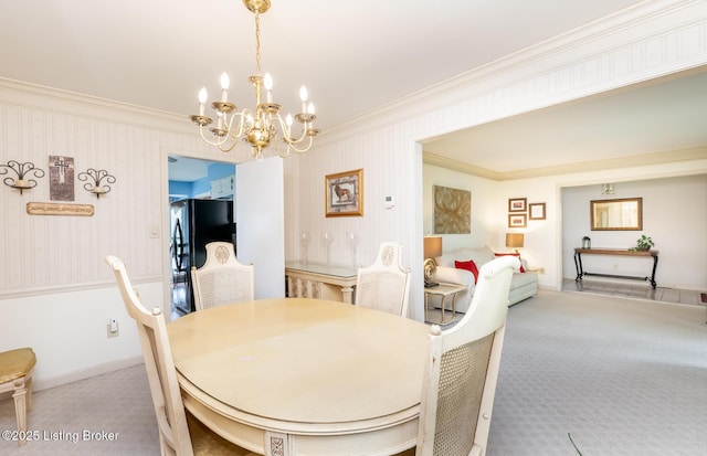 carpeted dining room featuring ornamental molding and a chandelier