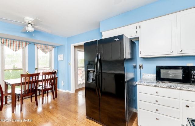 kitchen with ceiling fan, light stone countertops, light wood finished floors, white cabinetry, and black appliances