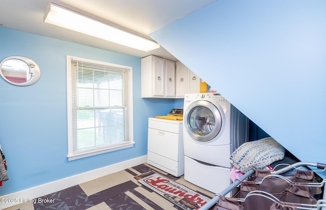 laundry area with washing machine and clothes dryer, baseboards, and cabinet space
