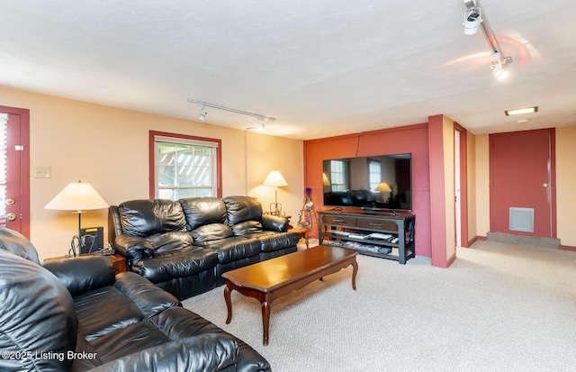 carpeted living room featuring visible vents and rail lighting