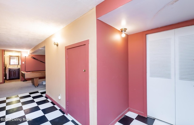 hall with a sink, tile patterned floors, and baseboards