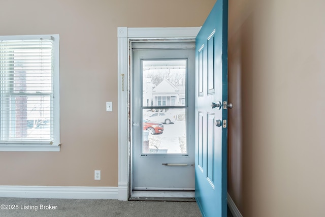 entryway with baseboards and carpet flooring