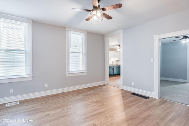 unfurnished bedroom with connected bathroom, a closet, visible vents, and light wood-type flooring