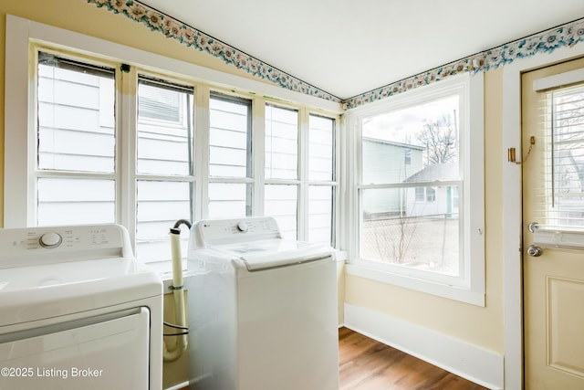 washroom featuring baseboards, laundry area, wood finished floors, and washer and clothes dryer
