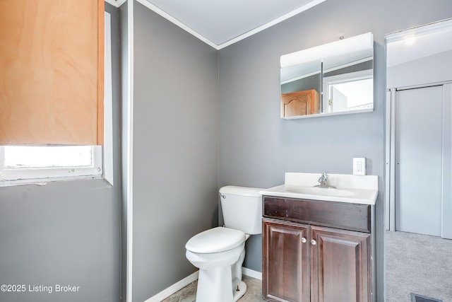 half bathroom with vanity, ornamental molding, and toilet