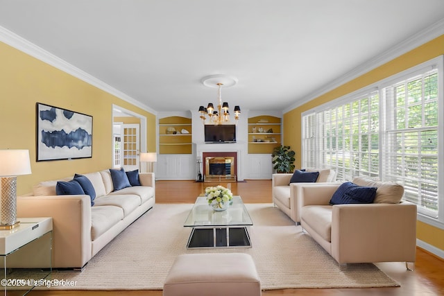 2224 Wynnewood Cir, Louisville, KY 40222 - living room with wood finished floors, a chandelier, built in shelves, crown molding, and baseboards