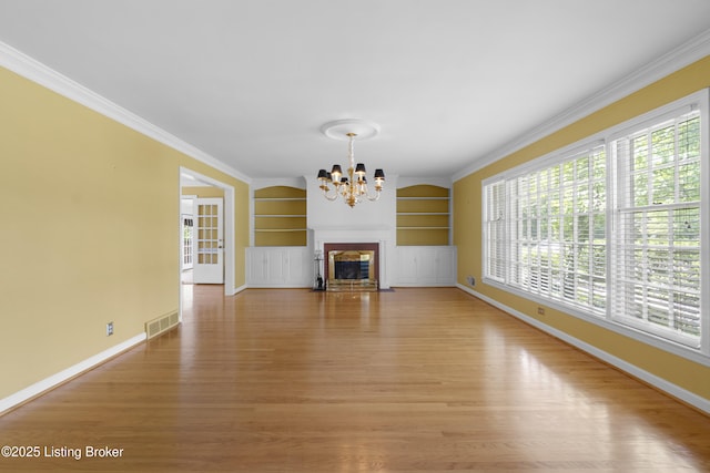 2224 Wynnewood Cir, Louisville, KY 40222 - unfurnished living room featuring a chandelier, plenty of natural light, built in shelves, baseboards, and crown molding