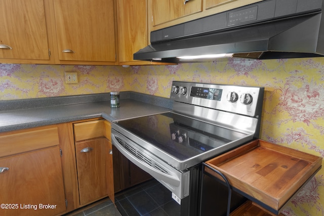 2224 Wynnewood Cir, Louisville, KY 40222 - kitchen with electric stove, wallpapered walls, under cabinet range hood, dark tile patterned floors, and dark countertops