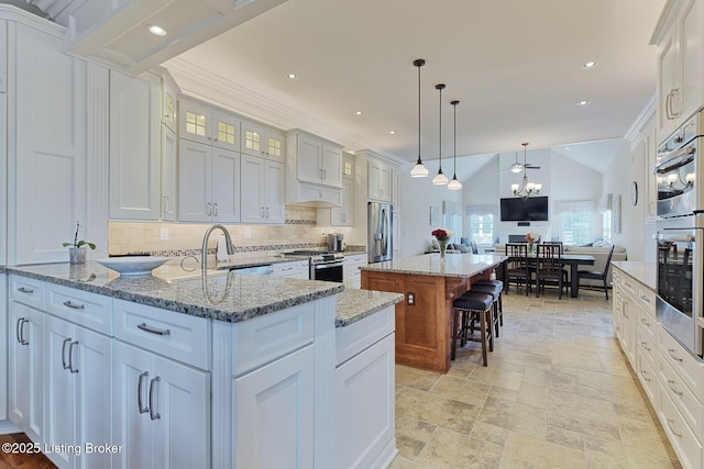 kitchen with a kitchen island, tasteful backsplash, a sink, open floor plan, and stainless steel appliances