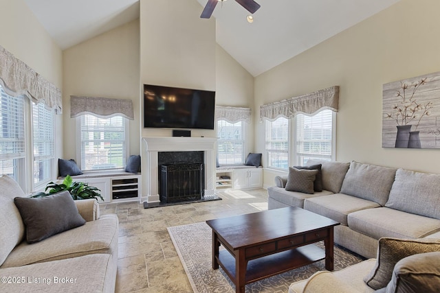 living room featuring high vaulted ceiling, ceiling fan, stone finish flooring, and a wealth of natural light