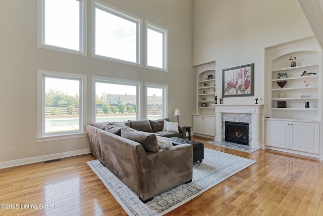 living area featuring plenty of natural light, visible vents, and a towering ceiling