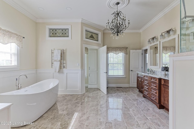 full bathroom with crown molding, vanity, a chandelier, marble finish floor, and a freestanding tub